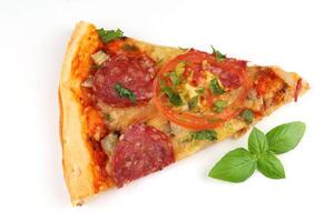 Sliced pizza on white isolate. Pizza and fresh basil. photo