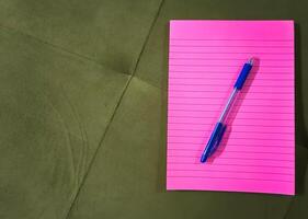 Top view of pink notebook with pencil placing over it photo