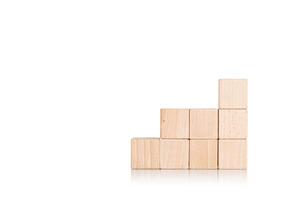 wooden cubes in the form of a ladder with a hand on an isolate white background photo