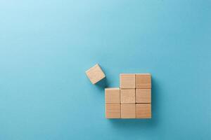 wooden cubes in a square of nine pieces in a row on a blue background photo