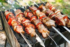 Cooking barbecue with vegetables on skewers. Roasted meat on the grill photo