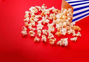 cardboard box with popcorn on a red background photo