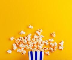 cardboard box with popcorn on a yellow background photo