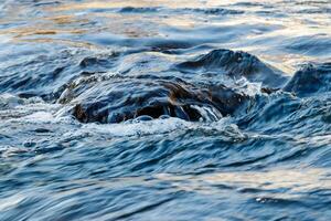 flow of water and spray from a stone photo