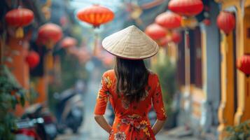 Vietnamese Woman in Traditional Dress Walking Through a Street Decorated With Lanterns photo
