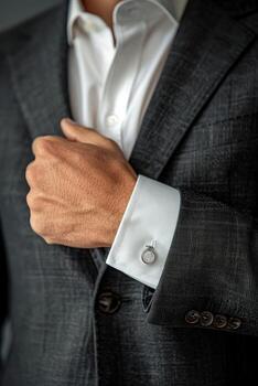 Man Adjusting Cufflinks on Suit photo