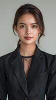 Young Thai Female in Black Suit Poses for Picture photo