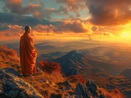 Monk Standing on Mountain Top at Sunset photo