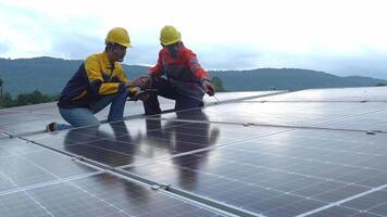 A team of engineers walked on the roof inspecting solar panels, carrying boxes of equipment and radio communications. video