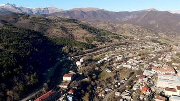 A beautiful bird's-eye view of the landscape.Footage.A bright view of the mountains with tall trees and residential buildings located on them and you can see the blue sky overhead. video