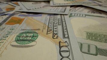 A close-up shot of a stack of hundred dollar bills, showing the intricate detail of the bills and the security features. video