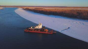 The view from the drone. Clip. A working ship at sea next to the forest and snow . video