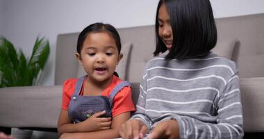 The sisters teach the sisters to read books with sofa background. video