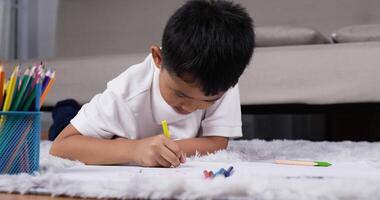 Front view of a cute little asian boy lying on warm floor with underfloor heating video