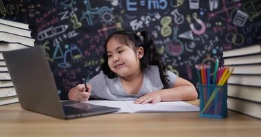 menina usando computador portátil para aprender desenhando dentro Sala de aula video