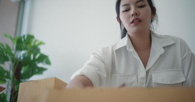 Handheld close up shot, Asian young woman opened the box to checking and write in notebook video