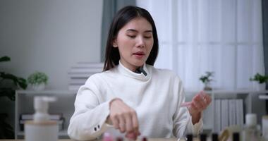 Footage of Beautiful asian woman blogger showing how to make up and use cosmetics. Influencer lady lives streaming cosmetics product reviews in the home studio. Influencer and cosmetics concepts. video
