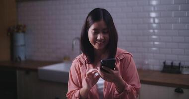 Footage of Young Asian woman talking video call with friend and holding a salad plate in kitchen at home,Healthy food and wellness concept