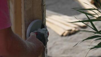 A man is using a power tool to cut wood. Concept of productivity and hard work. Slow motion video