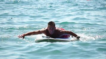 Man Sup Sea. Strong athletic man learns to paddle sup standing on board in open sea ocean on sunny day. Summer holiday vacation and travel concept. Aerial view. Slow motion video