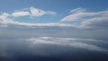 Aerial view. Blue sky sun and fog over calm sea. The drone flies over foggy and fluffy clouds. Abstract aerial nature summer ocean sunset sea and sky background. Vacation, travel and holiday concept. video