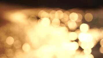 Abstract sea summer ocean sunset nature bokeh background. Small waves on azure water surface in motion blur with golden bokeh lights from sun. Holiday, vacation and recreational concept. Slow motion video