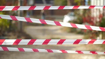 Red and white warning tape swinging in the wind. Protection sign. Don't cross the line. Red White caution tape pole fencing is protects for No entry. Backdrop without people, empty street. video