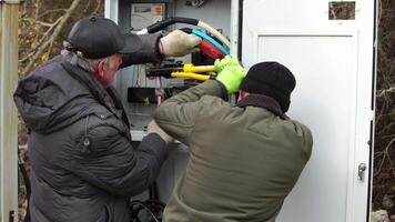 Close-up view of Electrician installing wires, cables into a electricity power shield, fuse box, an industrial electric panel with lots of colorful cables and wires. Power industry concept. video