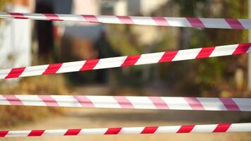 Red and white warning tape swinging in the wind. Protection sign. Don't cross the line. Red White caution tape pole fencing is protects for No entry. Backdrop without people, empty street. video