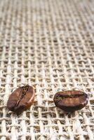 Close up from a few coffee beans laying down on a Burlap fabric background. Background voor coffee related products. photo