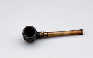 the pipe is an inlaid wooden object and is used for smoking tobacco. Here it is photographed against an isolated white background photo