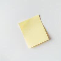 Blank yellow paper taped to the wall for writing messages. photo