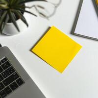 Blank yellow paper taped to the wall for writing messages. photo