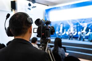 Asian man Videographer in backside are shooing and recording in Speech event on the stage. photo