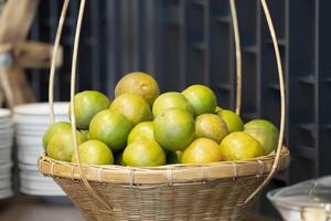 A bunch of oranges in a basket, based on the picture showed that it could be a party or a buffet somewhere else. photo