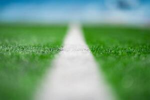 Close up to the White Touch Line of Green Artificial Grass Turf Outdoor on green soccer field. photo