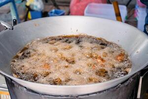 Asian Fried Chicken are fried by palm oil in the large pan. photo