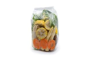Carrots, vegetables, corn, and golden needle mushrooms are ready for sale in transparence plastic bags on white background. Clipping Path. photo