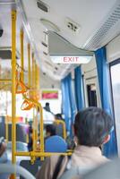 Exit sign light box is hung on the ceiling inside the bus, Thailand. photo