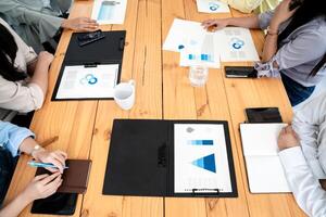 Employees Meeting in conference room. There are triangular diagrams, graphs, and related data set aside on a long brown wooden table. photo