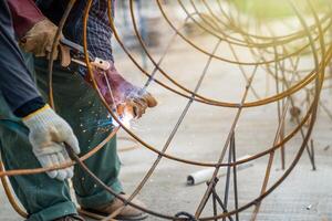 Blacksmith Technicians are welding several curve wires to form a structure. photo
