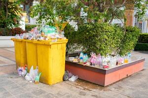 Garbage bins are overflowing since there are not enough receptacles and bins to handle the flow of waste for that area. photo