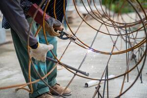 Blacksmith Technicians are welding several curve wires to form a structure. photo