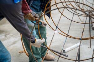 Blacksmith Technicians are welding several curve wires to form a structure. photo