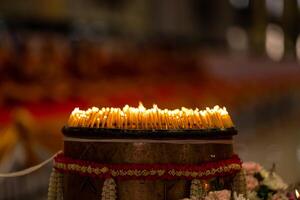 lighted candles laid out in circle in the dark with small white shadow on the right side of the background. photo