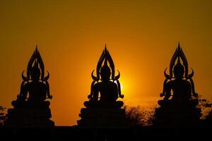 Silhouette Buddha statue between creating and building process, at outdoor field with the sun set and twilight period time., Thailand. photo