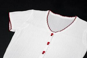 flat White knitwear sweater tshirt shape with red line on the rim on black background in studio light. photo