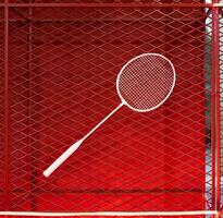 one badminton racket is hung on red grill by a cable tie for display in exhibition sports event photo
