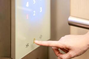 She is using her index finger to press the floor number that digital buttons in the elevator. photo