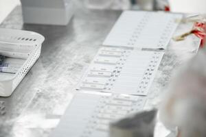 ATK results are place arranged on a paper number list on stainless silver table. photo